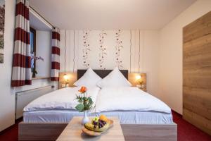 a bedroom with two beds and a bowl of fruit on a table at Hotel-Restaurant Straussen in Harburg