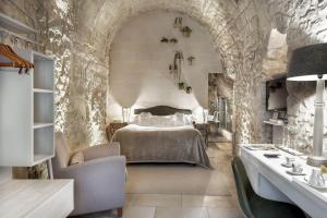 ein Schlafzimmer mit einem Bett in einer Steinmauer in der Unterkunft Locanda Don Serafino Historical Boutique Hotel in Ragusa