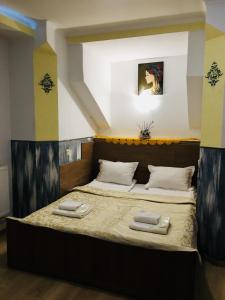 1 dormitorio con 1 cama con 2 toallas en Апартаменти готельного типу, en Leópolis