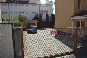 a fence in front of a building with a car at Nerudova SIX in Košice