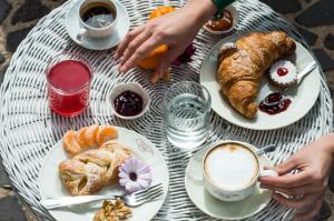 un tavolo con piatti di prodotti da forno e una tazza di caffè di Hotel Villa Canu a Càbras