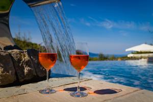 - deux verres de vin assis à côté de la piscine dans l'établissement Oleum, à Massa Lubrense