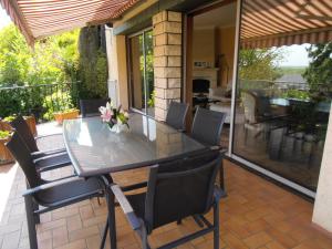 a dining table and chairs on a patio at La Fargette in Saint-Fargeau-Ponthierry