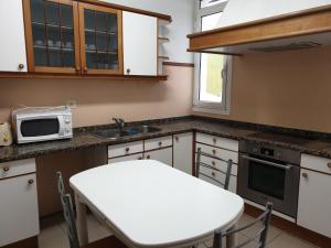 a kitchen with a white table and a microwave at Albergue San Martin in Tui