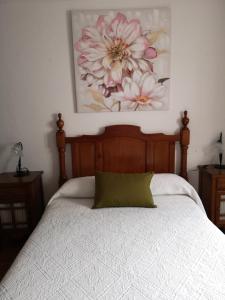 1 dormitorio con 1 cama con una pintura floral en la pared en Pensión Venta Julián HCA01134, en El Bosque