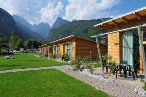 een resort met bergen op de achtergrond bij Bungalows Chalets Lago di Molveno in Molveno