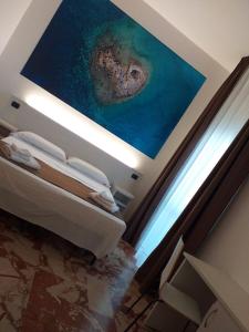 B&B L'Isola في بورتو سيساريو: غرفة نوم مع لوحة على السقف