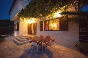 a wooden table and chairs in front of a house at Villa Kate in Vis