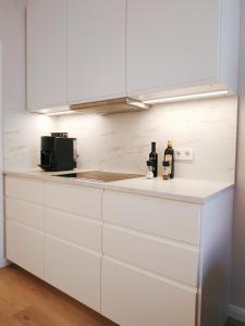 biała kuchnia z 2 butelkami wina na blacie w obiekcie Two-bedroom apartment 'Taupé' w Wiedniu