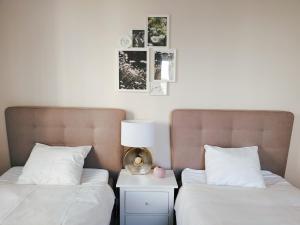 dwa łóżka z białą pościelą i lampką na stoliku nocnym w obiekcie Two-bedroom apartment 'Taupé' w Wiedniu