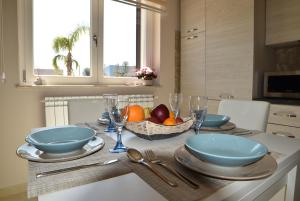 a table with plates and bowls and a basket of fruit at Appartamenti in villa Alessia in Monopoli