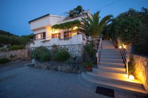 a house with stairs leading up to it at night at Villa Kate in Vis
