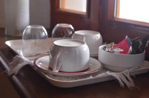 a table with a coffee cup and plates on a tray at L'uovo e la faina in Busca