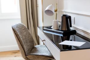 a desk with a chair and a coffee maker on it at Parisii Luxury Relais Rome-Fontana di Trevi in Rome