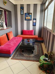 a living room with a red couch and a table at App Khouribga in Khouribga