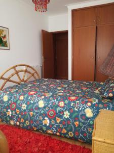 1 dormitorio con 1 cama con colcha de flores en Terraço da Baía en São Martinho do Porto