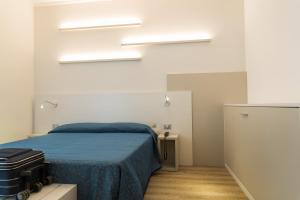 a bedroom with a bed with a blue blanket at Hotel Mara in Lido di Jesolo