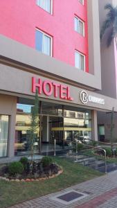 a hotel building with a hotel sign in front of it at Dunamys Hotel Londrina in Londrina