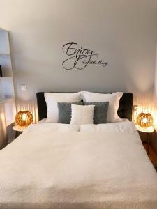 シギショアラにあるTeo's Flatのベッドルーム1室(白いベッド1台、壁に看板付)