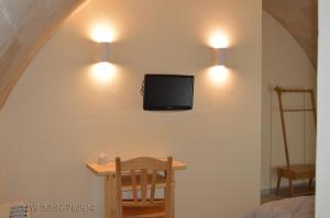 a room with a table and a tv on the wall at Mikasa in Matera