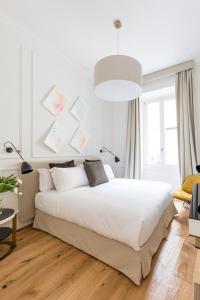 una camera con letto bianco e luce a ciondolo di Parisii Luxury Relais Rome a Roma