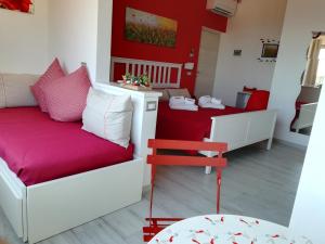 sala de estar con sofá y pared roja en B&B Capo al Piano en Marciana Marina