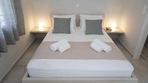 a large white bed with two white pillows on it at Armonia Houses in Tsonia