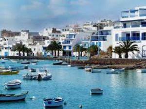 a group of boats in a body of water with buildings at Piso Arrecife Centro in Arrecife
