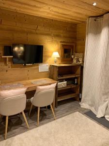a room with a table and a television in a cabin at Chez Fred et Carine (Petit-déjeuner bio inclus) in Auron