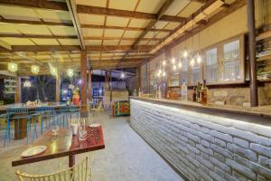 a restaurant with a bar with tables and chairs at Hotel Rock Manali -A Unit of Akhnoor Hotels Pvt Ltd in Manāli