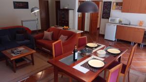 a living room with a dining table and a kitchen at Enjoy the best of countryside in Leiria