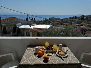 a table with food and drinks on a balcony at Roza's Home and Studios in Benitses
