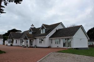 a row of white houses on a brick driveway at Elysian Fields B&B in Helston