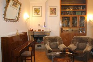 ein Wohnzimmer mit 2 Stühlen und einem Klavier in der Unterkunft Dali's Royal Apartment in Tbilisi City
