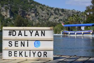 a sign on a dock with a boat in the water at B&B Boutique Hotel in Dalyan