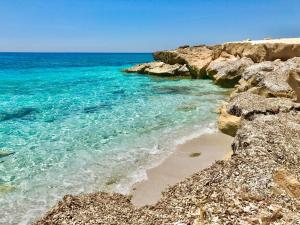 a beach with rocks and the blue ocean at West Sardinia Apartments in Càbras