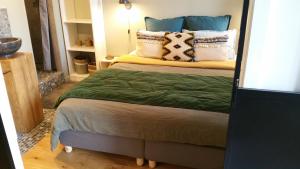 a bedroom with a bed with green sheets and pillows at Fiquet de Normanville pour votre bien être en plein coeur historique in Rouen