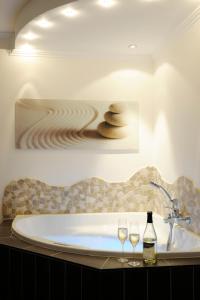 a bathroom with a tub with two wine glasses at Winneburger Hof in Ernst