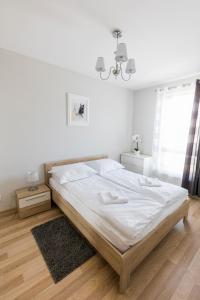 ein Schlafzimmer mit einem großen Bett mit weißer Bettwäsche in der Unterkunft Apartament 3d Szczecin in Stettin