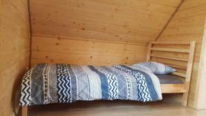 1 cama en una habitación de madera en una cabaña en Eko Przystanek, en Kępie Żaleszańskie