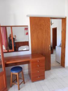 a wooden desk with a mirror and a stool at Socrates Studios & Apartments in Acharavi