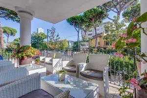 an outdoor patio with chairs and tables and trees at Hotel Il Gabbiano in Cesenatico