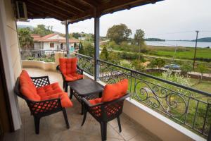 a balcony with chairs and tables and a view of the ocean at Villa Irini Ammousa in Ágios Nikólaos