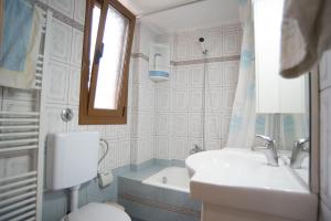 a bathroom with a sink and a toilet and a window at Villa Irini Ammousa in Ágios Nikólaos +23 photos
