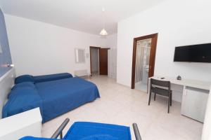 a bedroom with a blue bed and a desk at B&B Casa Alessio in Santa Domenica