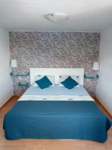 a bedroom with a blue bed with a stone wall at Apartmani Paulo in Vis