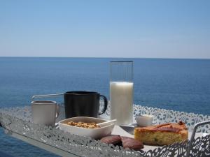einen Frühstückstisch mit einem Teller Essen und einem Glas Milch in der Unterkunft Sul Mare B&B in Diamante