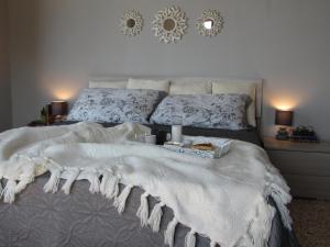 ein Bett mit einer weißen Decke und zwei Kerzen drauf in der Unterkunft Sul Mare B&B in Diamante