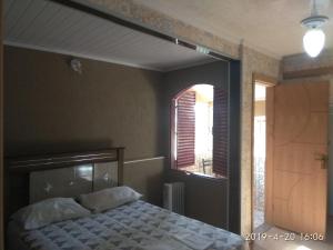 a bedroom with a bed and a window at Pousada Chalé Morada in Valparaíso de Goiás