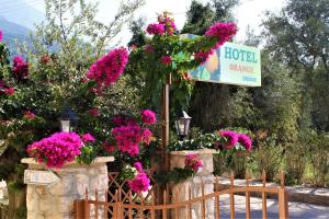 un ramo de flores en una valla con una señal en Hotel Orange, en Dhërmi